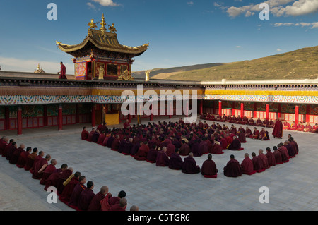 Yellow Hat Sect Tibetan Buddhist monks gather for evening prayers, Longwu Monastery, Tongren, Qinghai Province, China Stock Photo