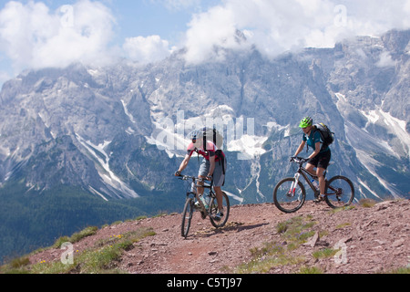 Italy, Dolomites, Couple mountainbiking Stock Photo