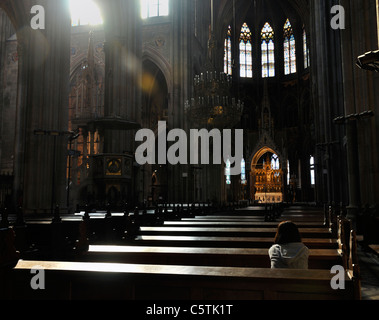 Young woman praying in church pew, rear view, Votive Church, Vienna, Austria, Europe Stock Photo