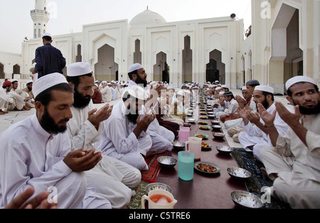 Faithful Muslims offer Dua (pray) before break their fast at a mosque during the first day of the Holy Month of Ramazan Stock Photo