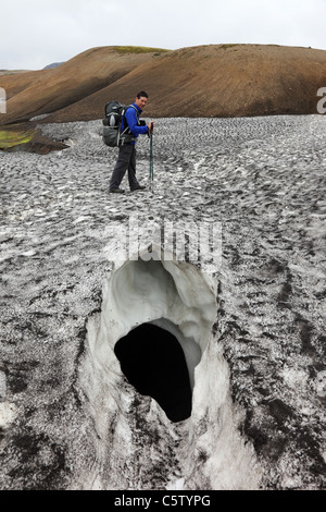 Walker Crossing a Crevasse in a Snow Field on the Laugavegur (Laugavegurinn) Hiking Trail Iceland Stock Photo