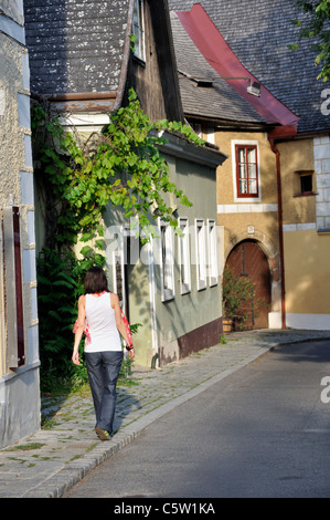 Young woman walking on sidewalk in Grinzing Vienna Austria Stock Photo