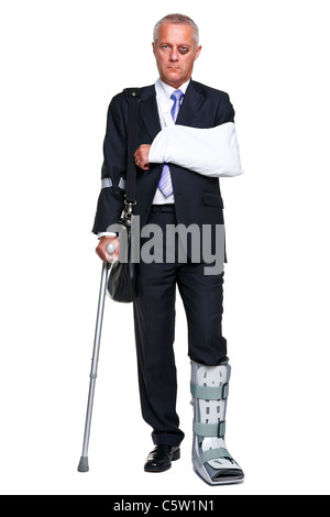 Photo of a badly injured businessman walking on cructhes carrying a briefcase, isolated on a white background. Stock Photo