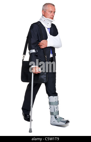 Photo of a badly injured businessman walking on cructhes carrying a briefcase, isolated on a white background. Stock Photo