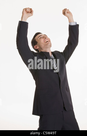 Businessman cheering, hands up, portrait Stock Photo