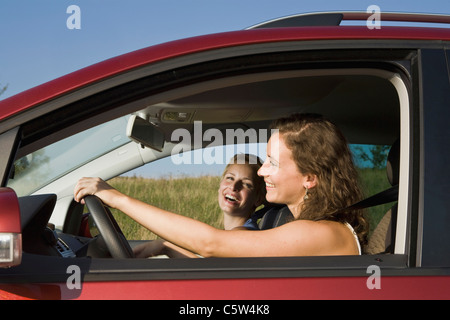 Germany, Bavaria, Two young women driving car, side view, portrait Stock Photo