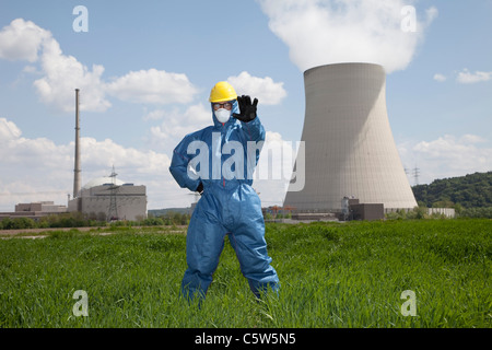 Germany, Bavaria, Unterahrain, Man with protective workwear standing in field at AKW Isar Stock Photo