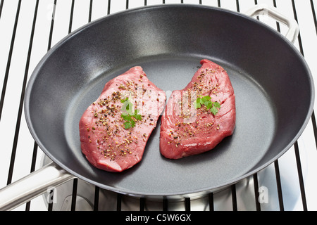 Raw steak in frying pan, elevated view Stock Photo