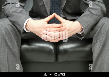 Close up of hands of nervous manager sitting on sofa Stock Photo