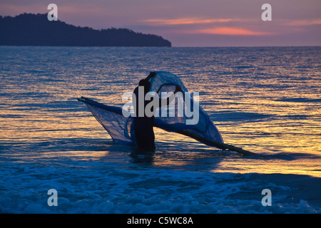 A fisherman throws a fishing net into the sea Stock Photo - Alamy