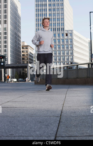 Germany, Berlin, Young man jogging, skyscrapers in background Stock Photo