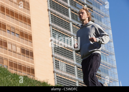 Germany, Berlin, Young man jogging, side view Stock Photo