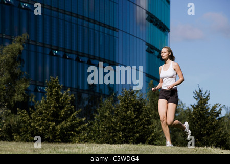 Germany, Berlin, Young woman jogging Stock Photo