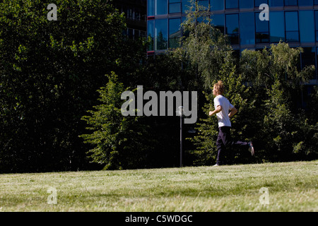 Germany, Berlin, Young man jogging, side view Stock Photo