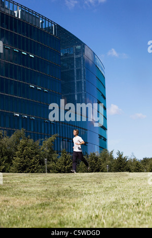 Germany, Berlin, Young man jogging, side view Stock Photo