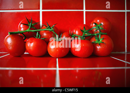 Fresh tomatoes on red tiles in the kitchen Stock Photo