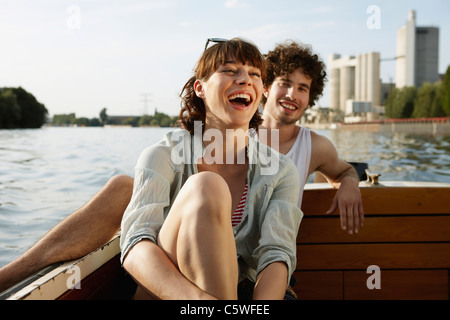 Germany, Berlin, Young couple on motor boat, laughing, portrait Stock Photo