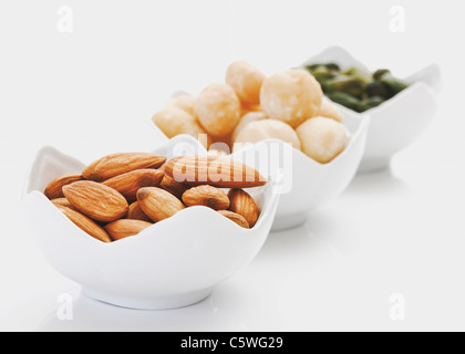 Bowls of various nuts on white background Stock Photo