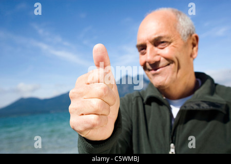 Germany, Bavaria, Walchensee, senior man giving "thumbs up" Stock Photo