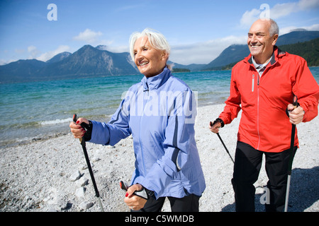 Germany, Bavaria, Walchensee, Senior couple, Nordic Walking on lakeshore Stock Photo