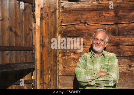 Austria, Senior man, arms crossed, smiling, portrait Stock Photo