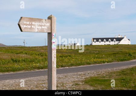 A signpost for the Machair Way long distance footpath in front of the Polochar Inn on the Hebridean island of South Uist. Stock Photo