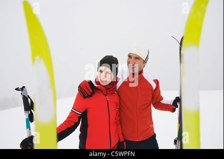 Italy, South Tyrol, Couple in winter clothes, skis in foreground Stock Photo