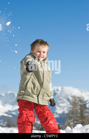 Italy, South Tyrol, Seiseralm, Boy (3-4) throwing snow in the air, portrait Stock Photo