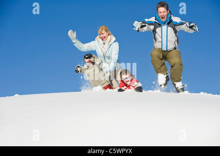 Italy, South Tyrol, Seiseralm, Family jumping in snow Stock Photo