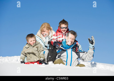 Italy, South Tyrol, Seiseralm, Family sitting in snow, portrait Stock Photo