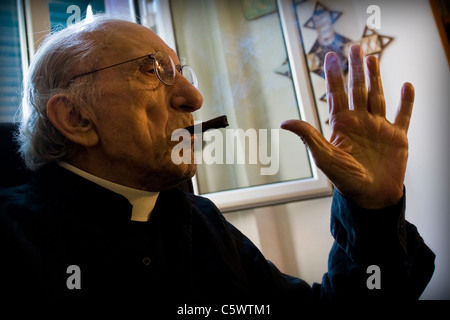 Don Andrea with the inevitable cigar in an interview. Don Andrea Gallo, Genoa, Italy Stock Photo