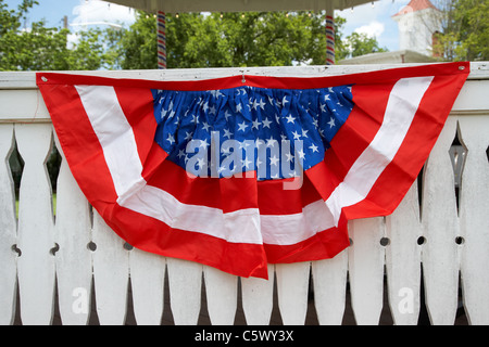 red white and blue american flag bunting put out on white fence for the 4th july usa Stock Photo