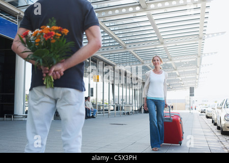 Germany, Leipzig-Halle, Airport, Woman with suitcase, Man holding flowers Stock Photo