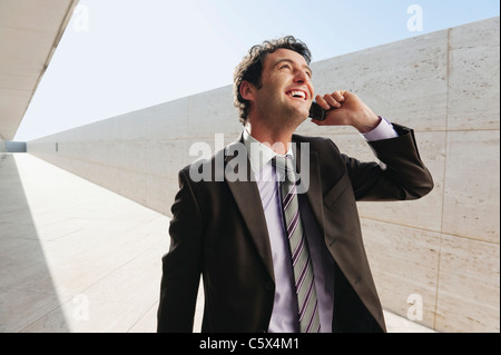 Spain, Mallorca, Businessman using mobile phone, looking up Stock Photo