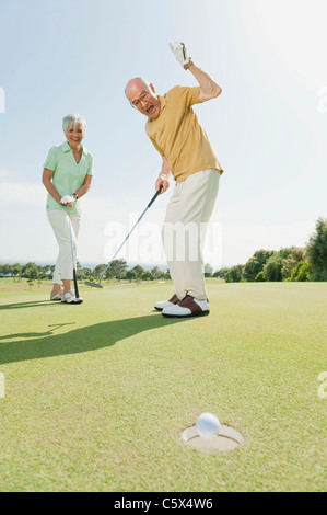 Spain, Mallorca, Senior couple on golf course, man cheering Stock Photo