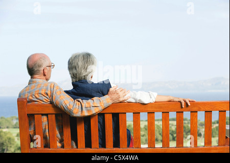 Spain, Mallorca, Senior couple sitting on bench, rear view Stock Photo