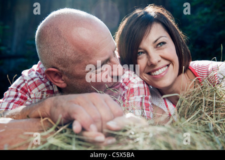 Germany, Bavaria, Couple lying on haystack Stock Photo