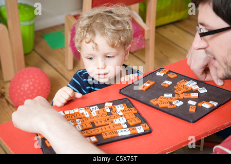 Germany, Berlin, Father and son (3-4) playing with toy tiles Stock Photo