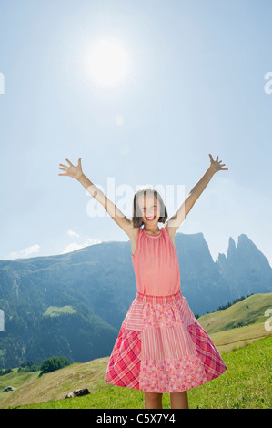 Italy, South Tyrol, Seiseralm, Girl (10-11) cheering in meadow, smiling, portrait Stock Photo