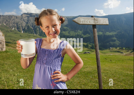 Italy, South Tyrol, Seiseralm, Girl (6-7) holding a glass of milk, portrait Stock Photo