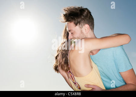Germany, Berlin, Young couple embracing, side view, portrait Stock Photo