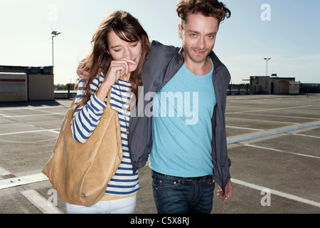 Germany, Berlin, Young couple, arm in arm, walking on park level Stock Photo