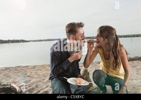 Germany, Berlin, Lake Wannsee, Young couple having a barbecue Stock Photo