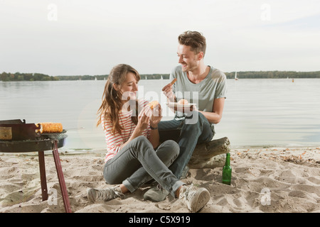 Germany, Berlin, Lake Wannsee, Young couple having a barbecue Stock Photo