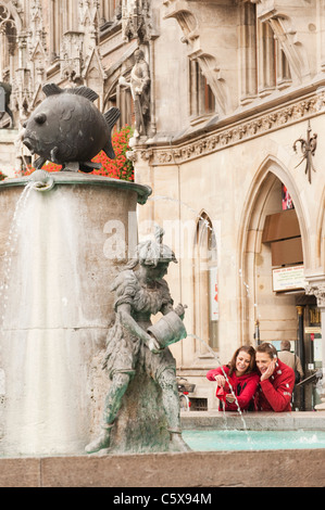 Germany, Bavaria, Munich, Couple standing by fountain Stock Photo