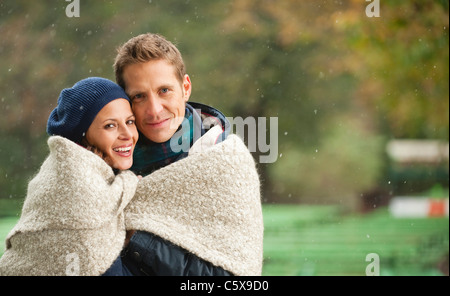 Germany, Bavaria, Munich, English Garden, Couple wrapped in blanket, portrait Stock Photo