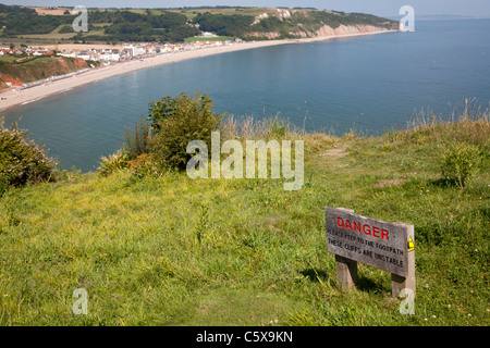 Warning sign for unstable cliffs on clifftop, Seaton, Devon Stock Photo