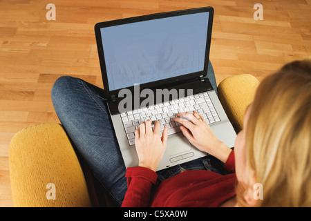 Young woman using laptop, elevated view, close-up Stock Photo