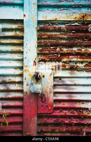 Metal entrance door with rusty padlock Stock Photo