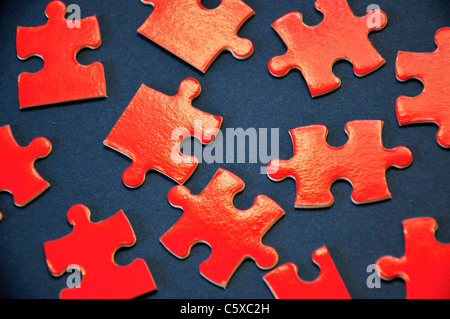 Pieces of a red puzzle on a blue background Stock Photo